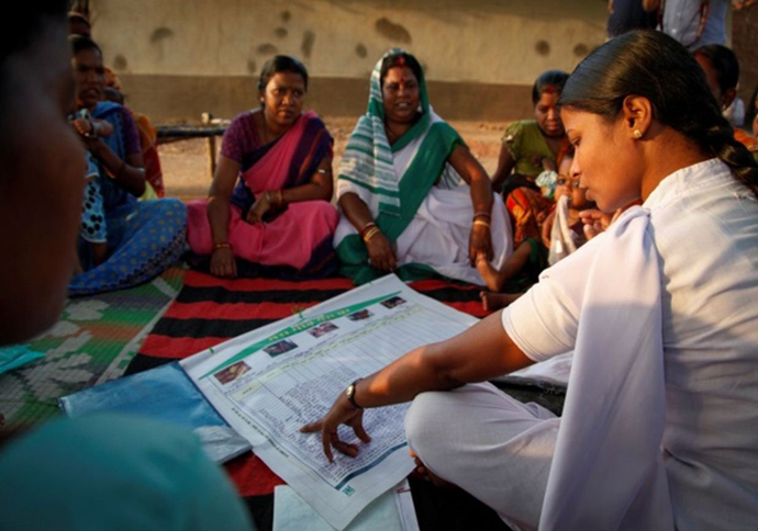 Community members in a village in eastern India learn about the “My Village My Home” tool at a vaccination session.