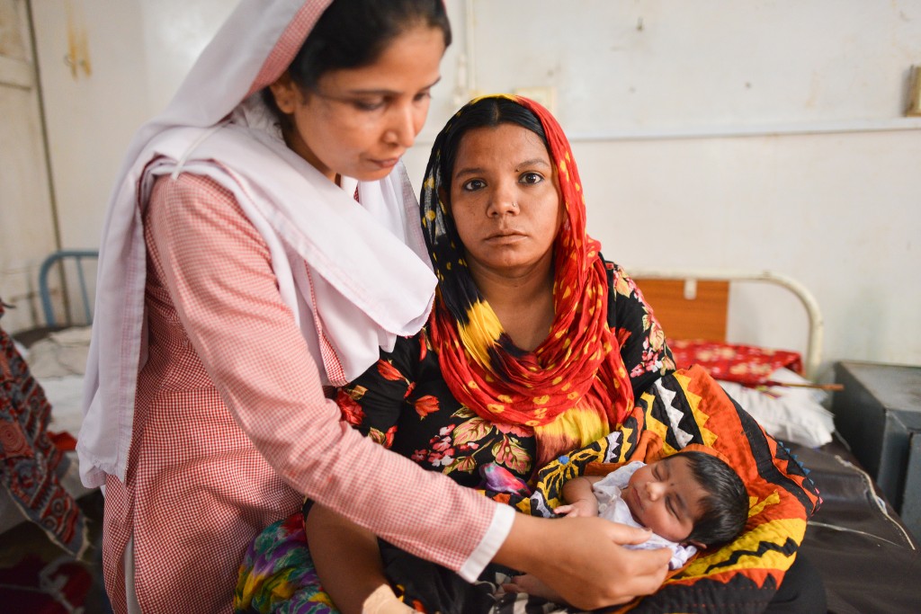 Woman holding newborn in Pakistan