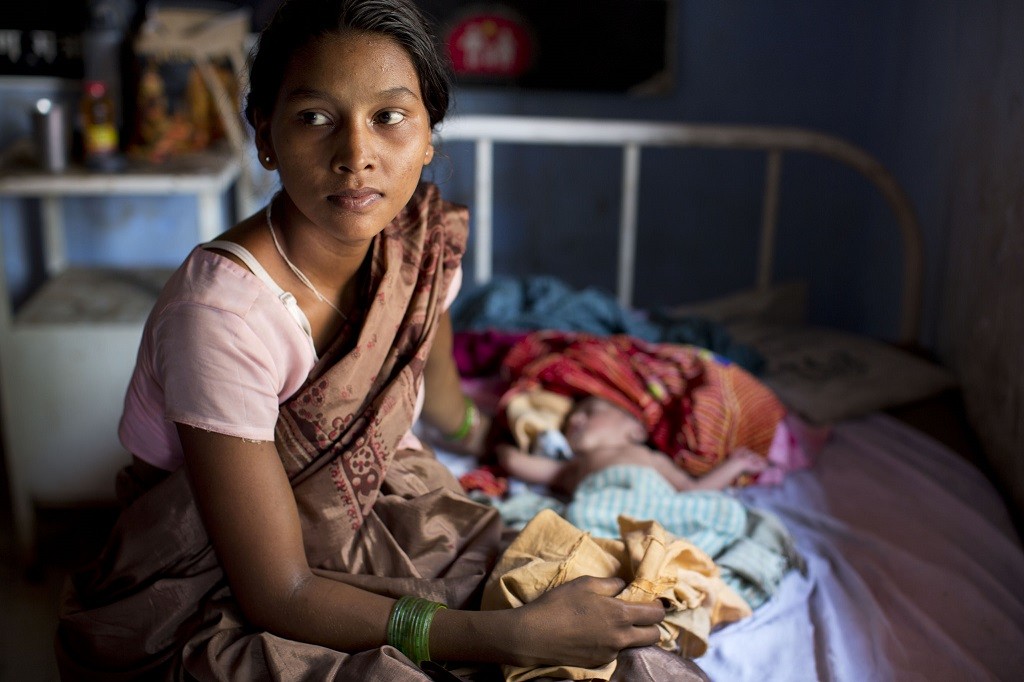 A mother holds her newborn in Kolibera Health Centre near Ranchi, India