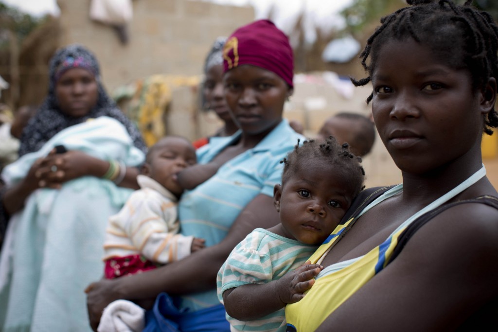 omen wait with their babies outside a health care center in Nampula, Mozambique.