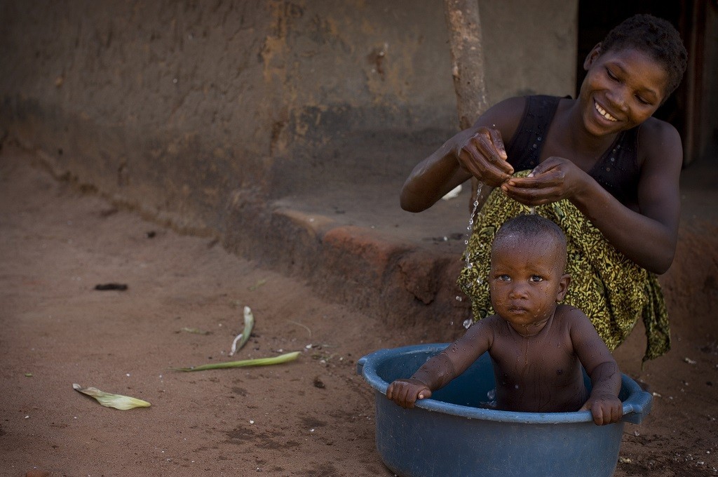 A woman washes her baby in the village of Bokola, Tanzania.