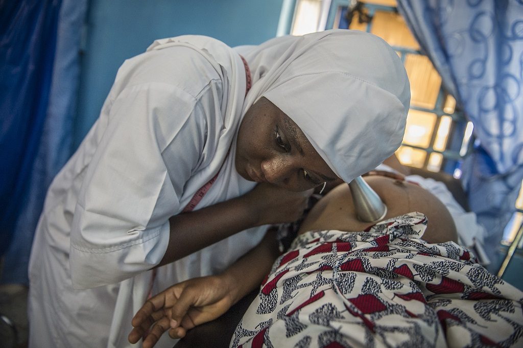 Midwife examins a pregnant woman at a clinic in Nigeria