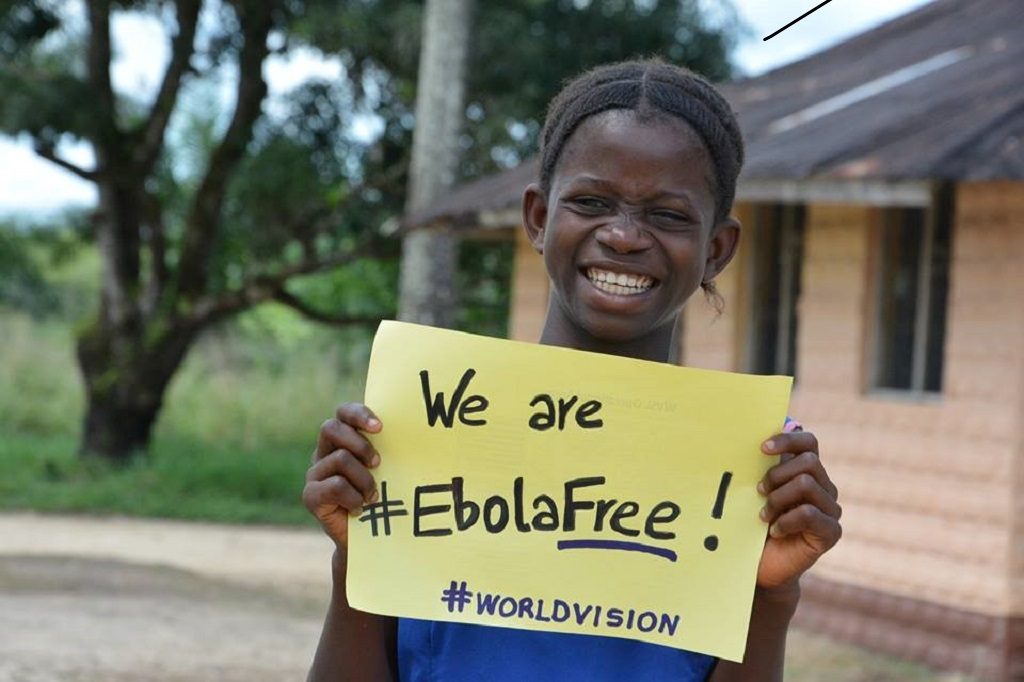 Girl holding "we are #EbolaFree!" sign