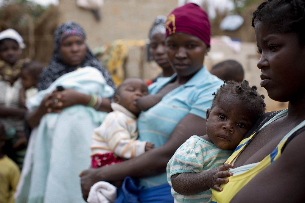 Women wait with their babies outside a maternal health care center in Nampula, Mozambique