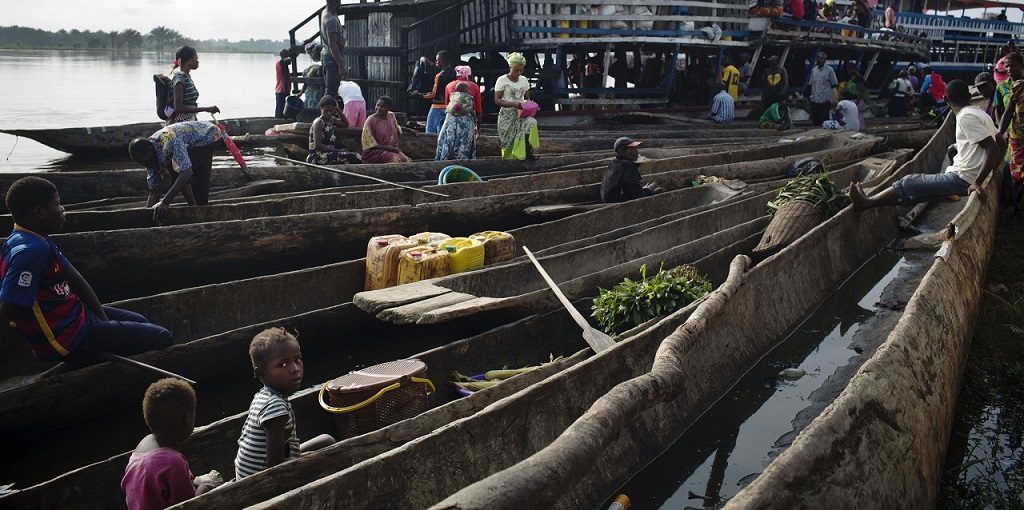A young girl sits in a pirogue at the main ferry port in Isangi, Tshopo, Democratic Republic of Congo