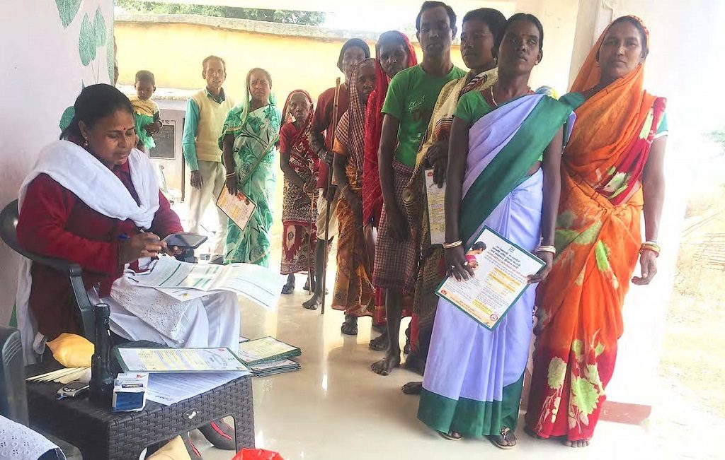 Women, men and children wait for services at an MCSP-supported health and wellness center in India.