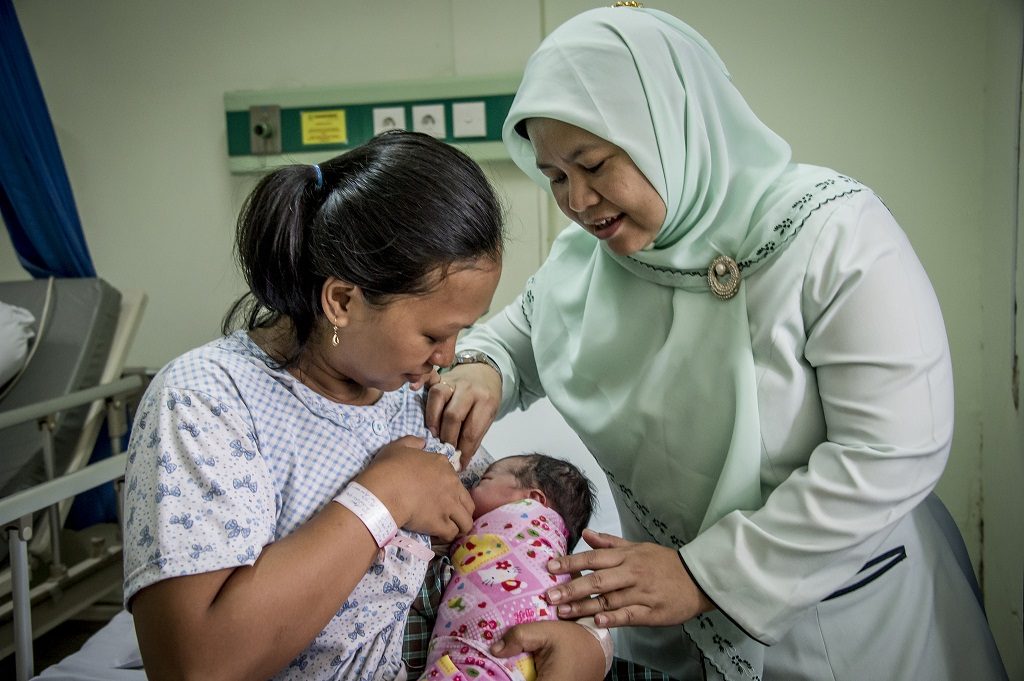Midwife, mother and newborn in Indonesia hospital