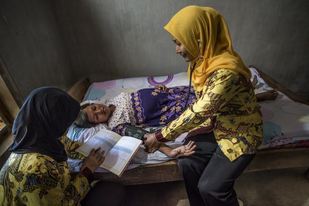 A nurse in Indonesia takes the blood pressure of a pregnant woman with suspected pre-eclampsia.