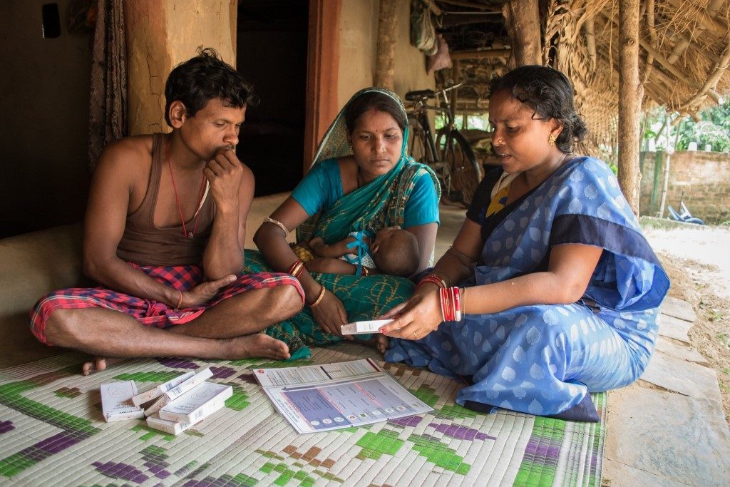 Couple with baby in India discussing birth control methods